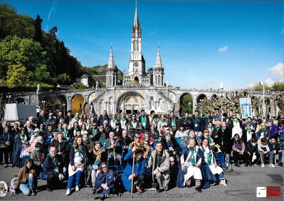 Photo de l'Hospitalité avec les personnes accompagnées devant la Basilique Notre-Dame-du-Rosaire à Lourdes