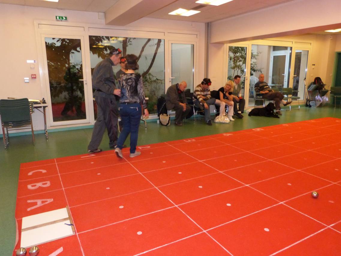 Photo d'une partie de pétanque adaptée dans la grande salle du siège de Voir Ensemble