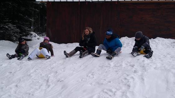 Les jeunes font de la luge sur une pente très enneigée.