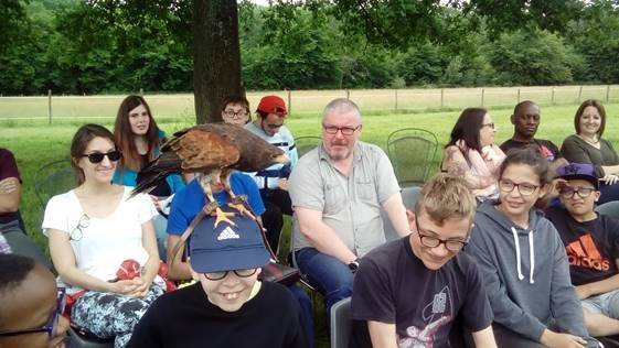 Une sortie du groupe de jeunes avec des accompagnateurs dans un parc animalier. Un faucon s'est posé sur la tête (casquettée heureusement) d'un jeune.